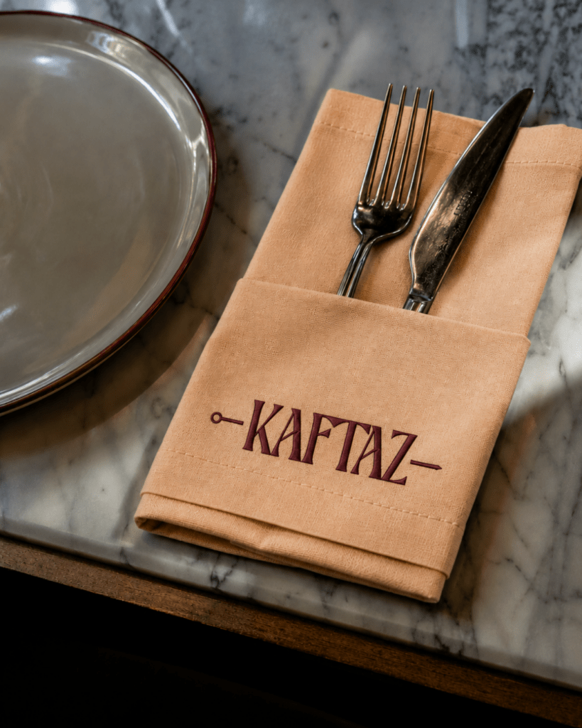 Mesa posta da KAFTAZ com guardanapo kraft carimbado com a marca